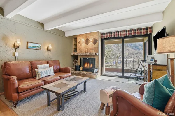 a living room with furniture a flat screen tv and a floor to ceiling window