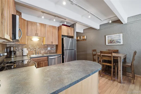 a kitchen with stainless steel appliances granite countertop a stove refrigerator sink and cabinets