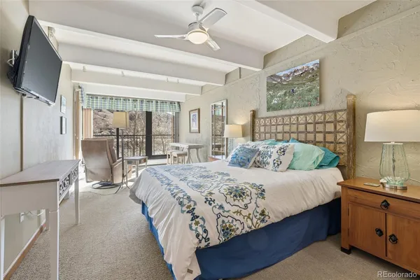 a bedroom with a large bed and a chandelier