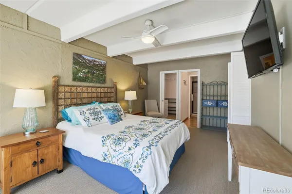 a bedroom with a bed and a flat tv screen on dresser