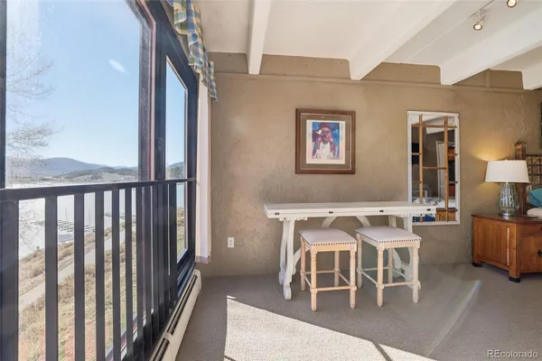 a dining room with furniture and a floor to ceiling window