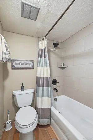 a white toilet sitting next to a bath tub