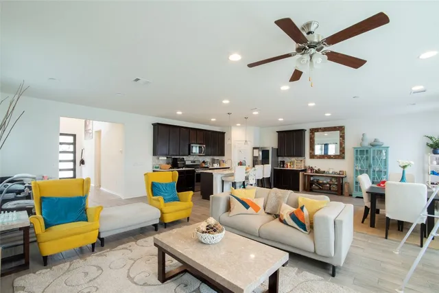 a living room with furniture kitchen view and a flat screen tv