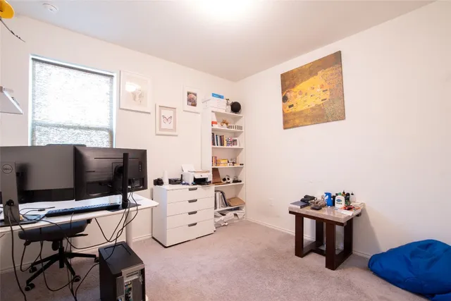 a view of a workspace with furniture and a window