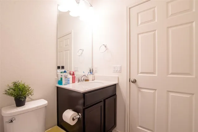 a bathroom with a sink toilet and a mirror