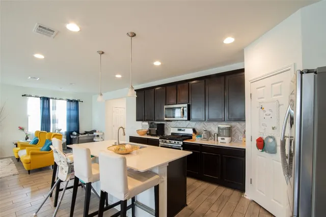a kitchen with a refrigerator and a dining table