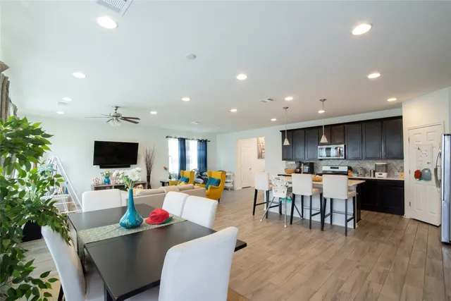a living room with furniture kitchen view and a flat screen tv