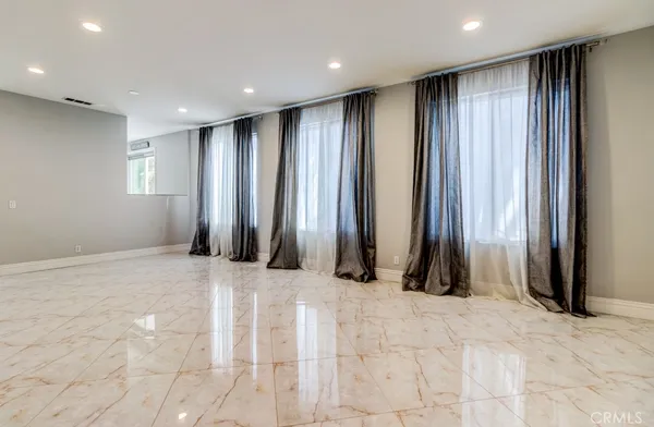 a view of an empty room with a fireplace and a window