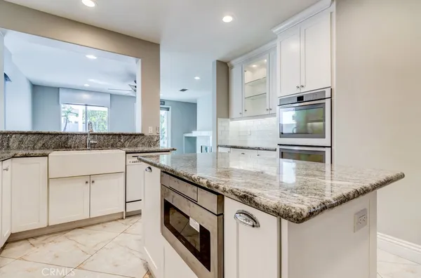 a kitchen with stainless steel appliances granite countertop a sink and a refrigerator