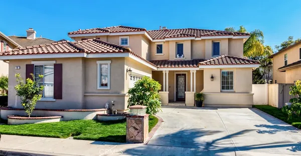 a front view of a house with a yard and potted plants