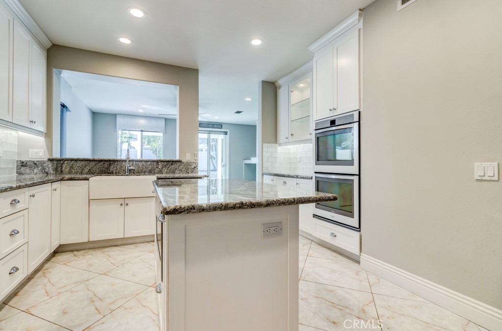 8 Zinnia Irvine, CA 92618 - Photo 21 of 63 a kitchen with stainless steel appliances granite countertop a sink and cabinets