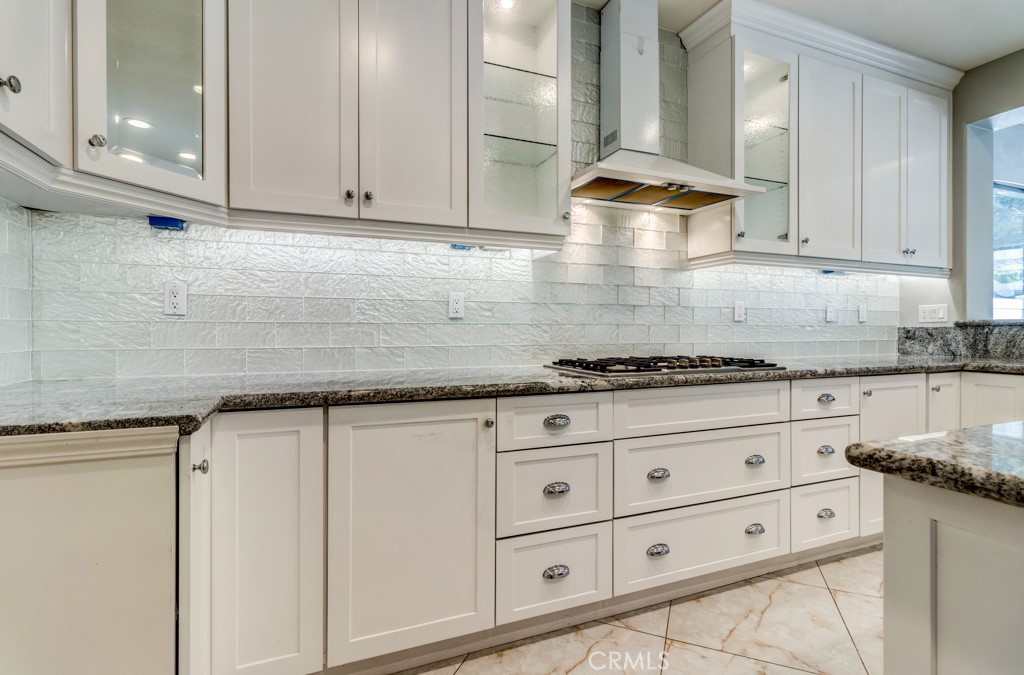 8 Zinnia Irvine, CA 92618 - Photo 22 of 63 a kitchen with granite countertop white cabinets and white appliances