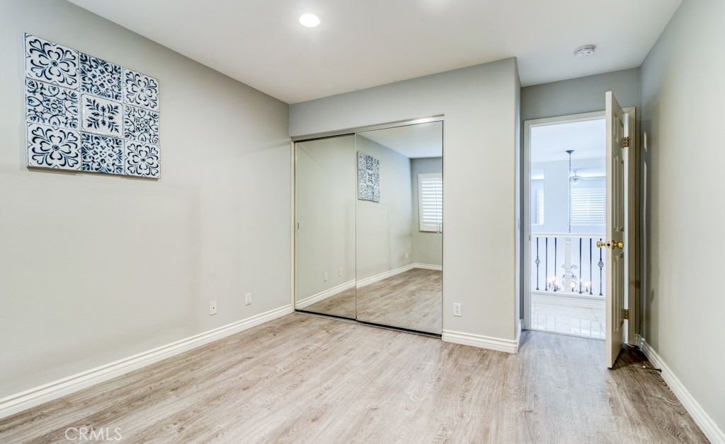 8 Zinnia Irvine, CA 92618 - Photo 41 of 63 an empty room with wooden floor and a bathroom