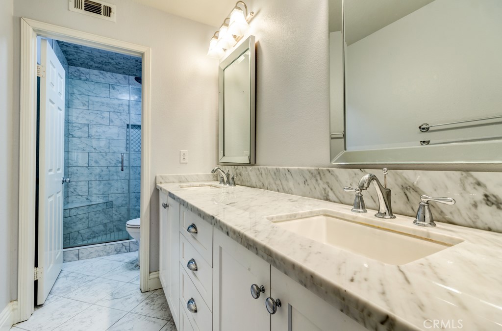 8 Zinnia Irvine, CA 92618 - Photo 43 of 63 a bathroom with a granite countertop sink and a mirror