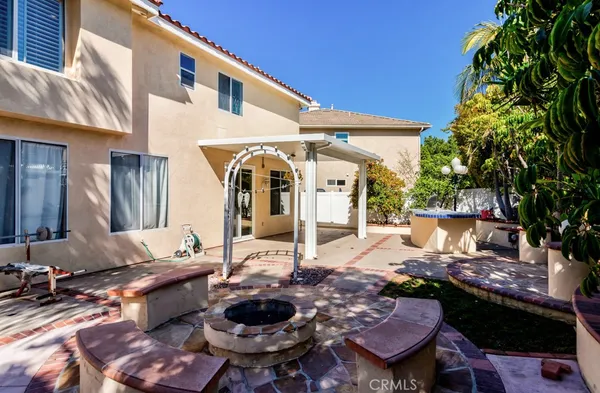 a view of a backyard with couches under an umbrella