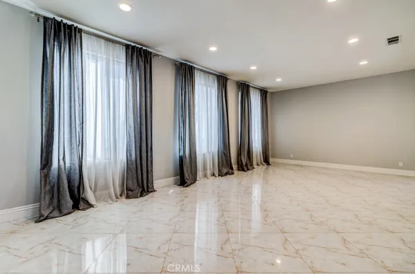 an empty room with windows and a fireplace