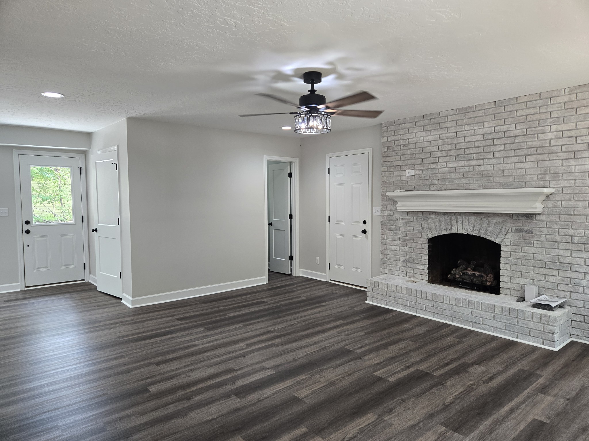 7 Bush Court Waverly, TN 37185 - Photo 23 of 48 a view of a livingroom with a fireplace a chandelier fan and wooden floor