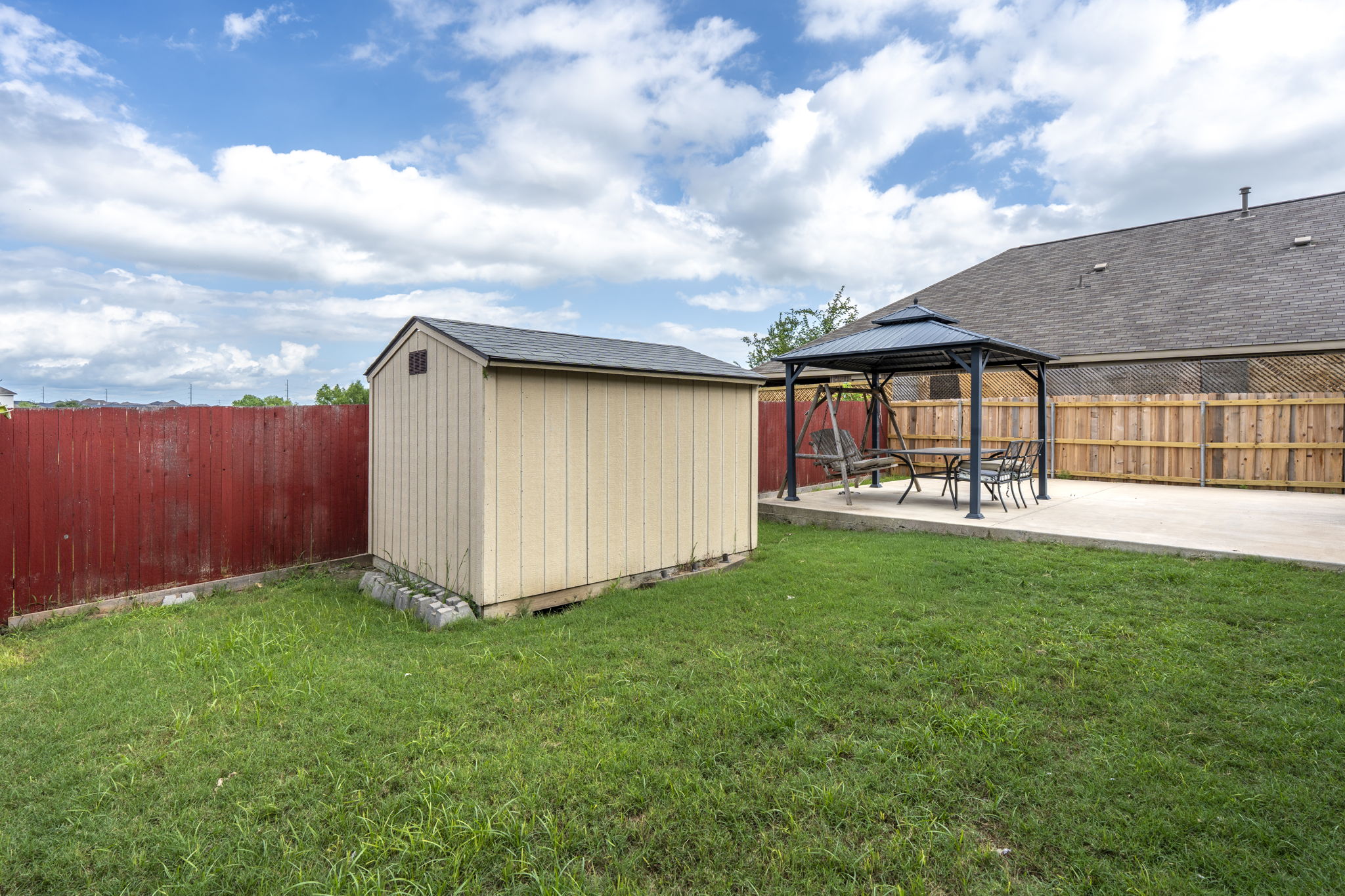 373 Rough Bark Street Buda, TX 78610 - Photo 26 of 39 A private backyard oasis features a storage shed and a covered patio area perfect for outdoor dining and relaxation.