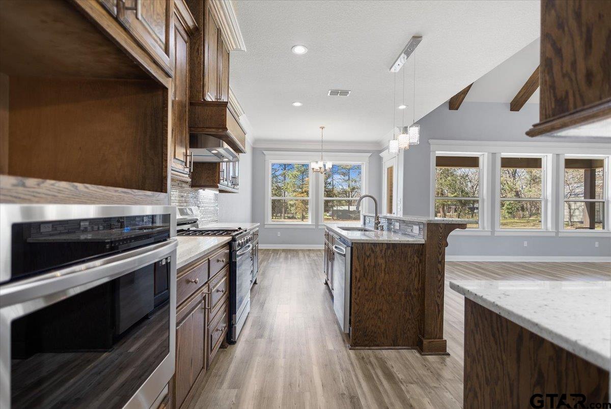 9629 Matise Street Tyler, TX 75706 - Photo 18 of 48 a kitchen with stainless steel appliances granite countertop a lot of counter space and wooden floors