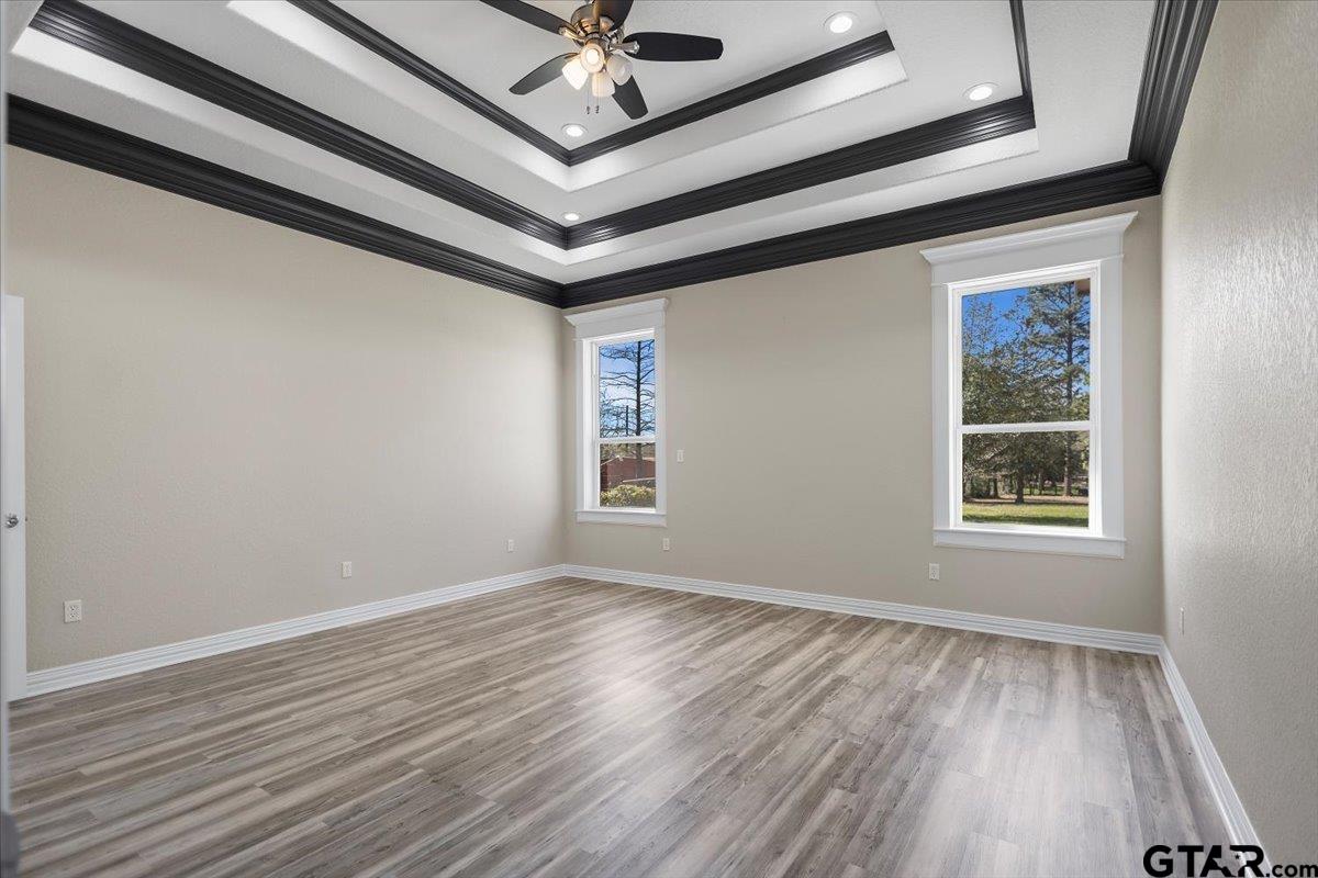 9629 Matise Street Tyler, TX 75706 - Photo 19 of 48 an empty room with wooden floor chandelier fan and windows