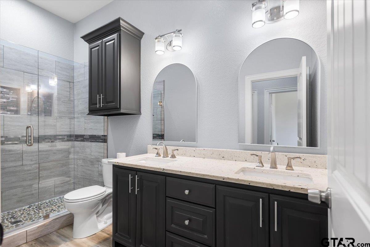 9629 Matise Street Tyler, TX 75706 - Photo 35 of 48 a bathroom with a double vanity sink toilet and a mirror