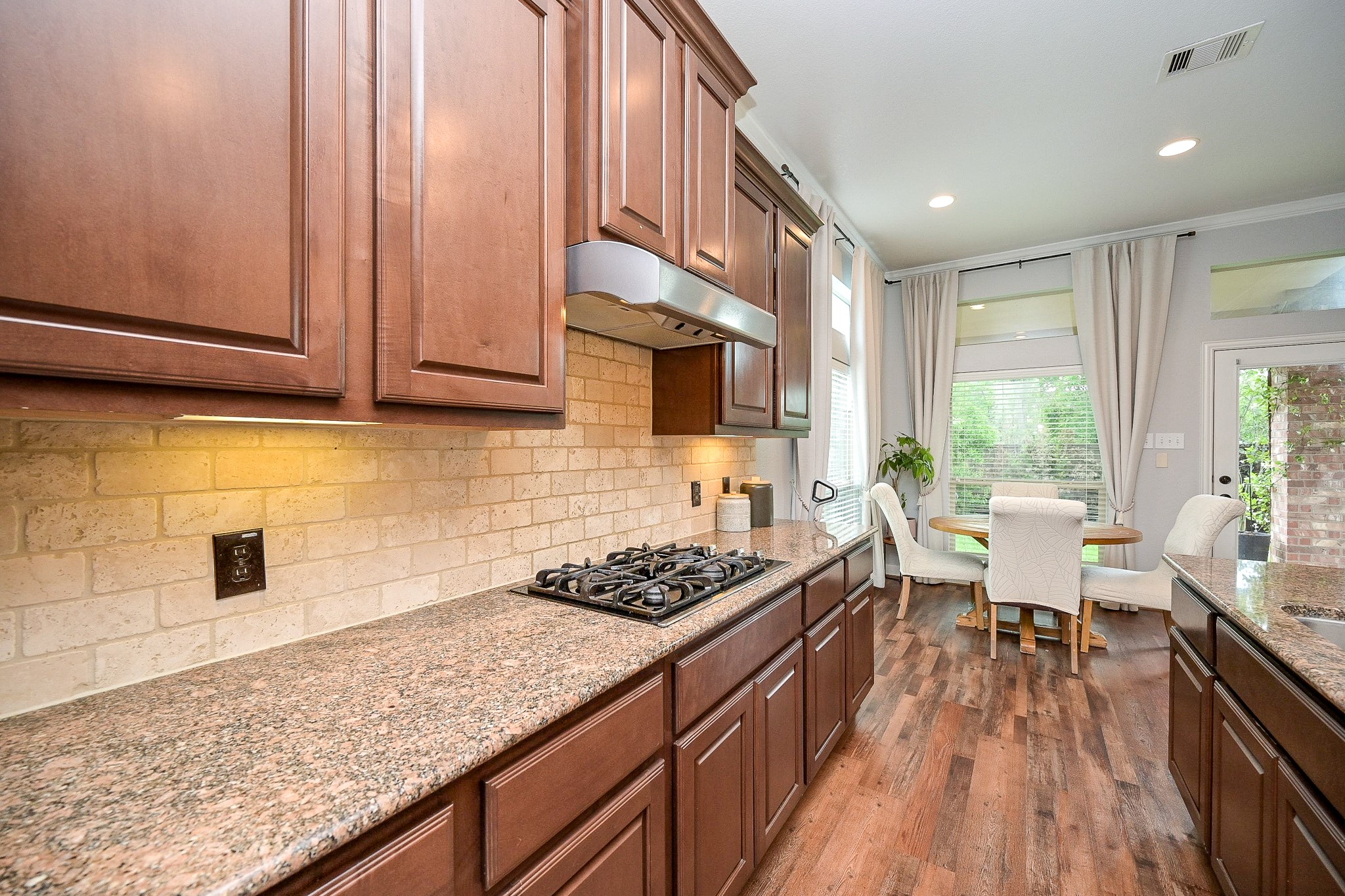 11 South Victoriana Circle Spring, TX 77389 - Photo 14 of 38 a kitchen with stainless steel appliances granite countertop a stove a sink dishwasher and cabinets with wooden floor