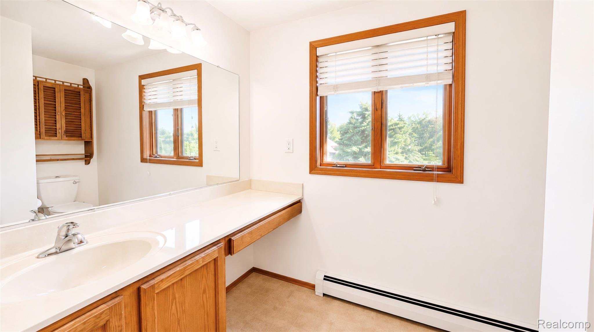 2232 London Bridge Drive, Unit 42 Rochester, MI 48307 - Photo 14 of 20 Bathroom vanity with an integrated sink, polished chrome faucet, and a large wall-mounted mirror