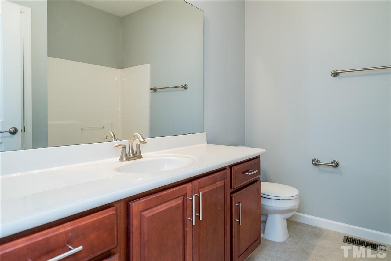 1539 Rodessa Run Raleigh, NC 27607 - Photo 22 of 25 a bathroom with a granite countertop sink a toilet and a mirror