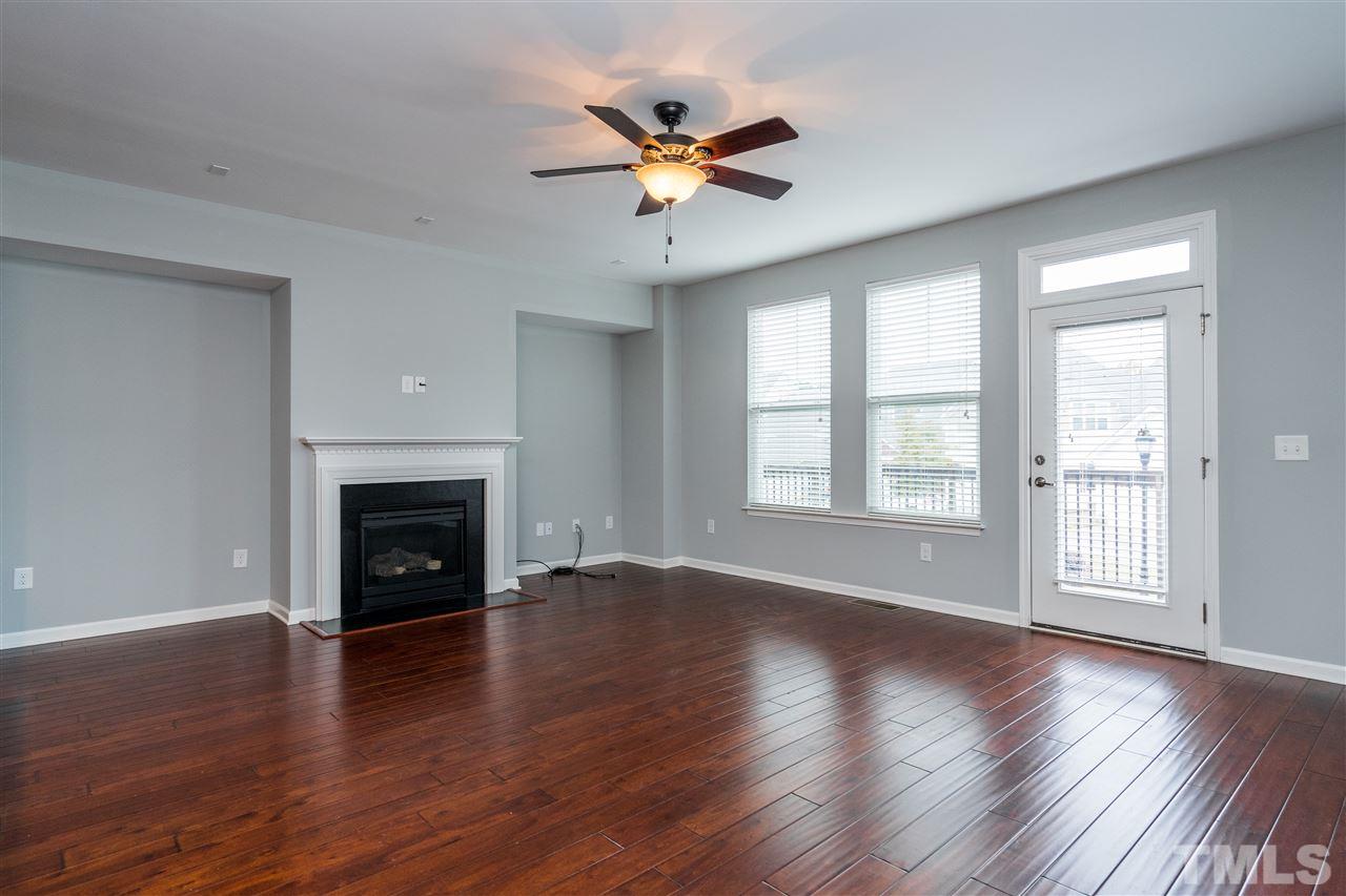 1539 Rodessa Run Raleigh, NC 27607 - Photo 25 of 25 an empty room with wooden floor a fireplace and a window