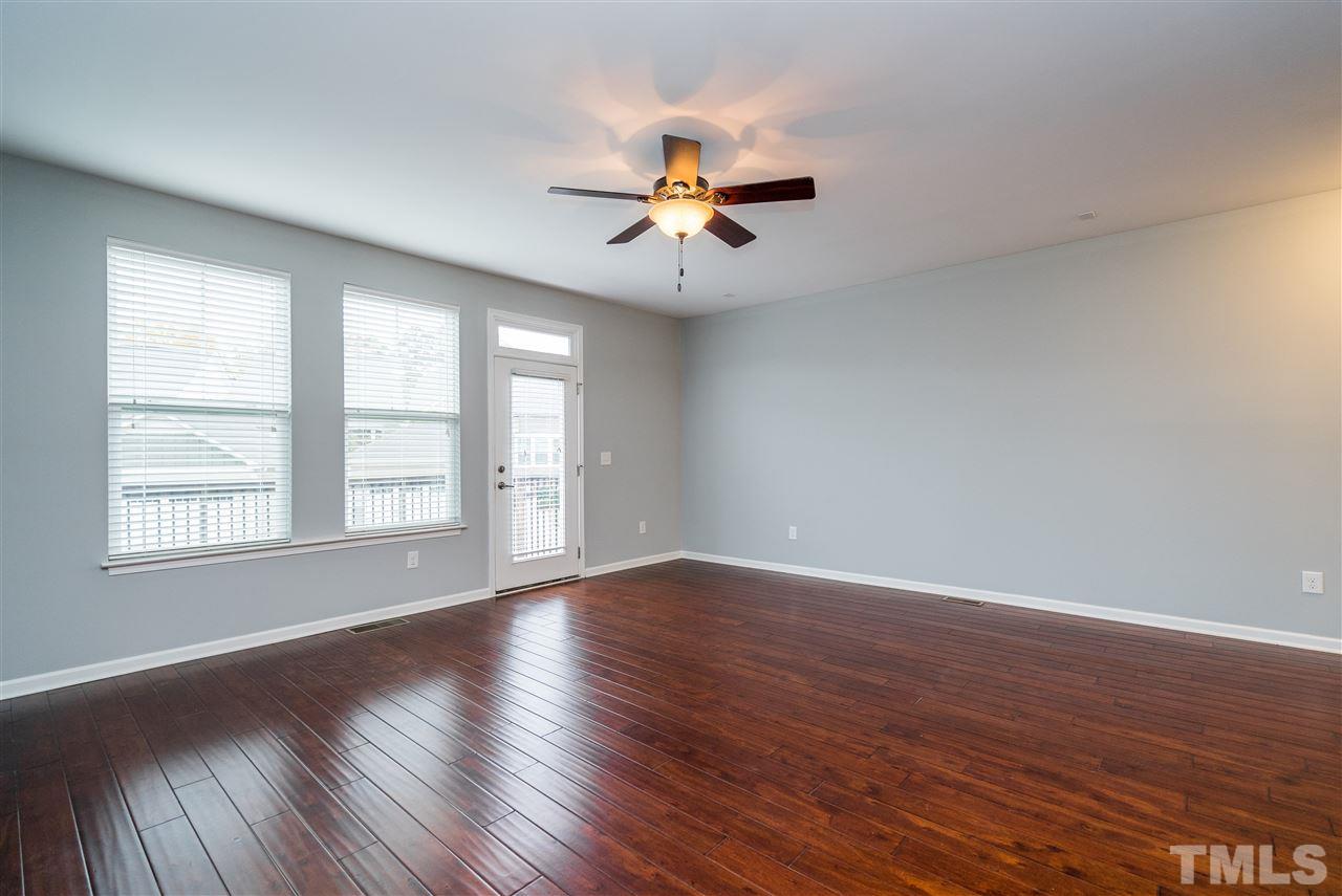 1539 Rodessa Run Raleigh, NC 27607 - Photo 9 of 25 an empty room with wooden floor ceiling fan and windows