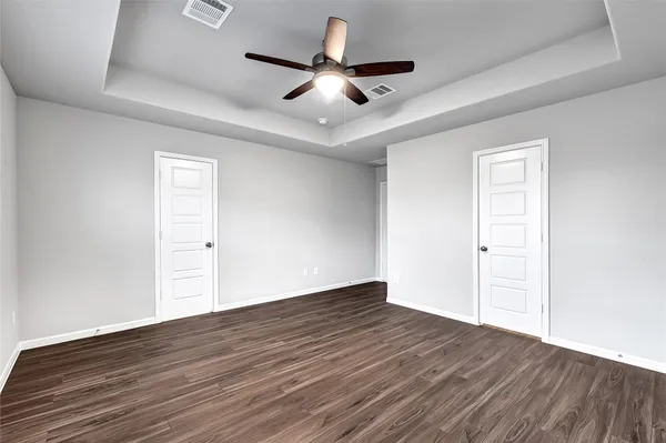 a view of an empty room with wooden floor