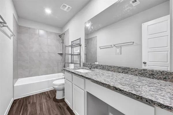 a bathroom with a granite countertop sink toilet and shower