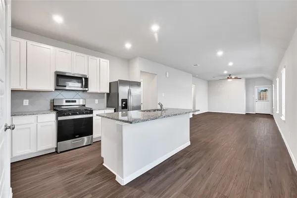 a kitchen with stainless steel appliances granite countertop a stove a sink and a refrigerator