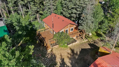 an aerial view of a house with yard deck and trees