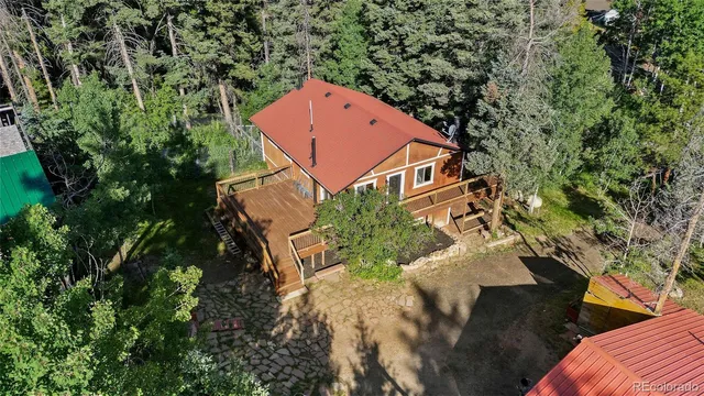 an aerial view of a house with yard deck and trees