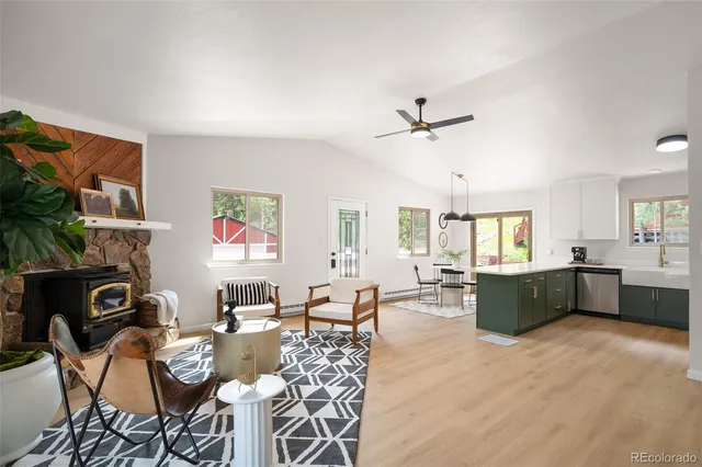 a living room with furniture kitchen view and a window