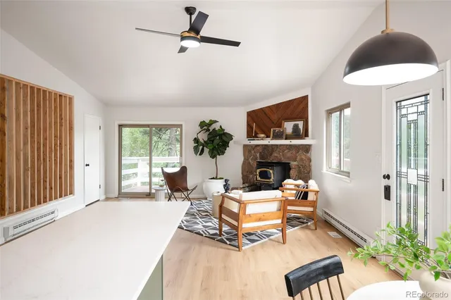 a living room with furniture a fireplace and a large window