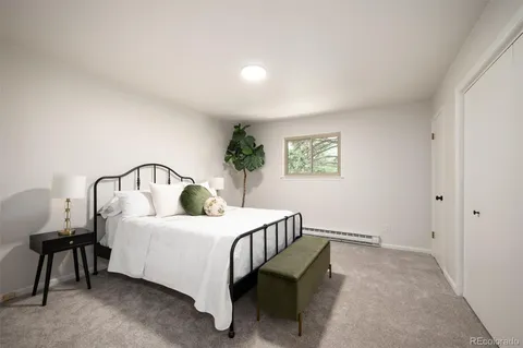 a bedroom with a bed a table and painting on the wall