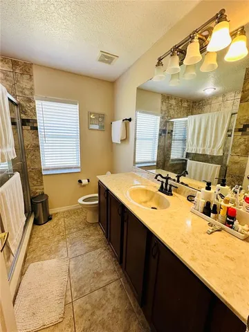 a spacious bathroom with a sink double vanity granite and a mirror