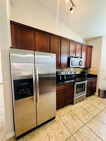 a kitchen with granite countertop stainless steel appliances and wooden cabinets