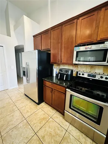 a kitchen with granite countertop a refrigerator and a stove top oven