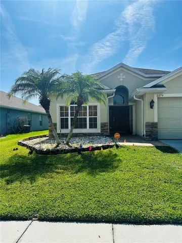 a view of a house with a swimming pool and a yard