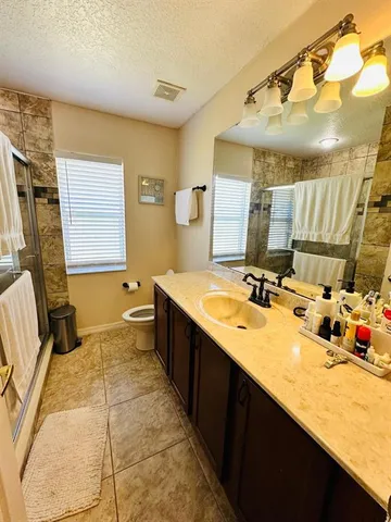 a spacious bathroom with a sink double vanity granite and a mirror