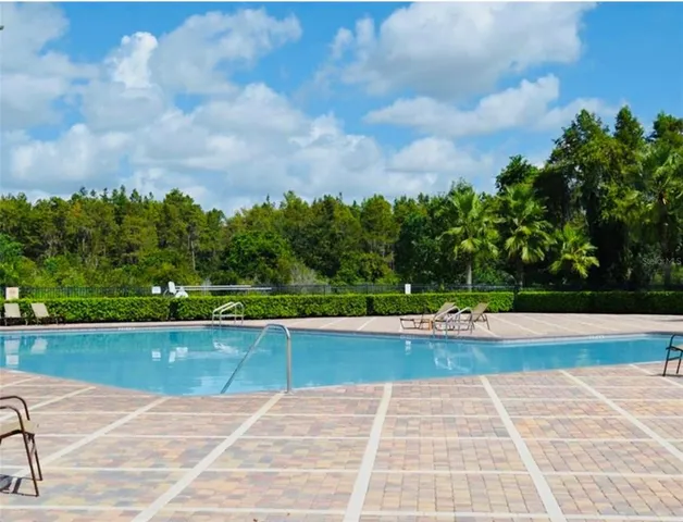 a view of swimming pool and trees in the background