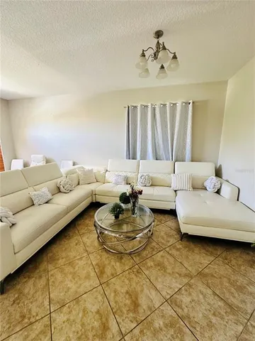 a living room with furniture and a chandelier