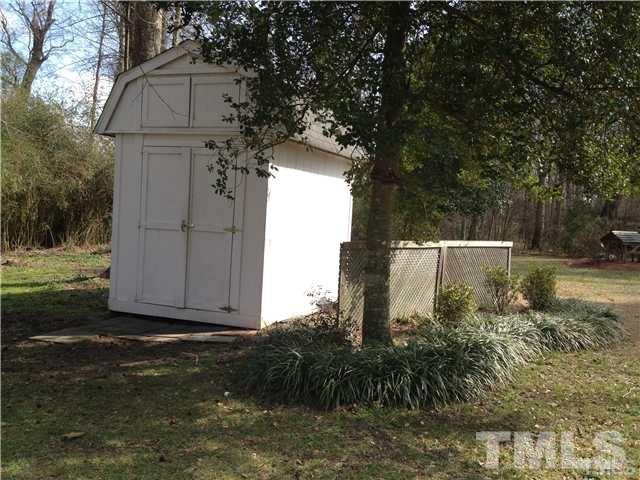 6299 Wimberly Road Willow Spring, NC 27592 - Photo 22 of 25 a view of backyard with large tree and wooden fence