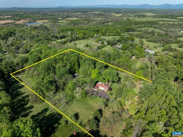a view of a hallway to a livingroom with wooden floor and furniture