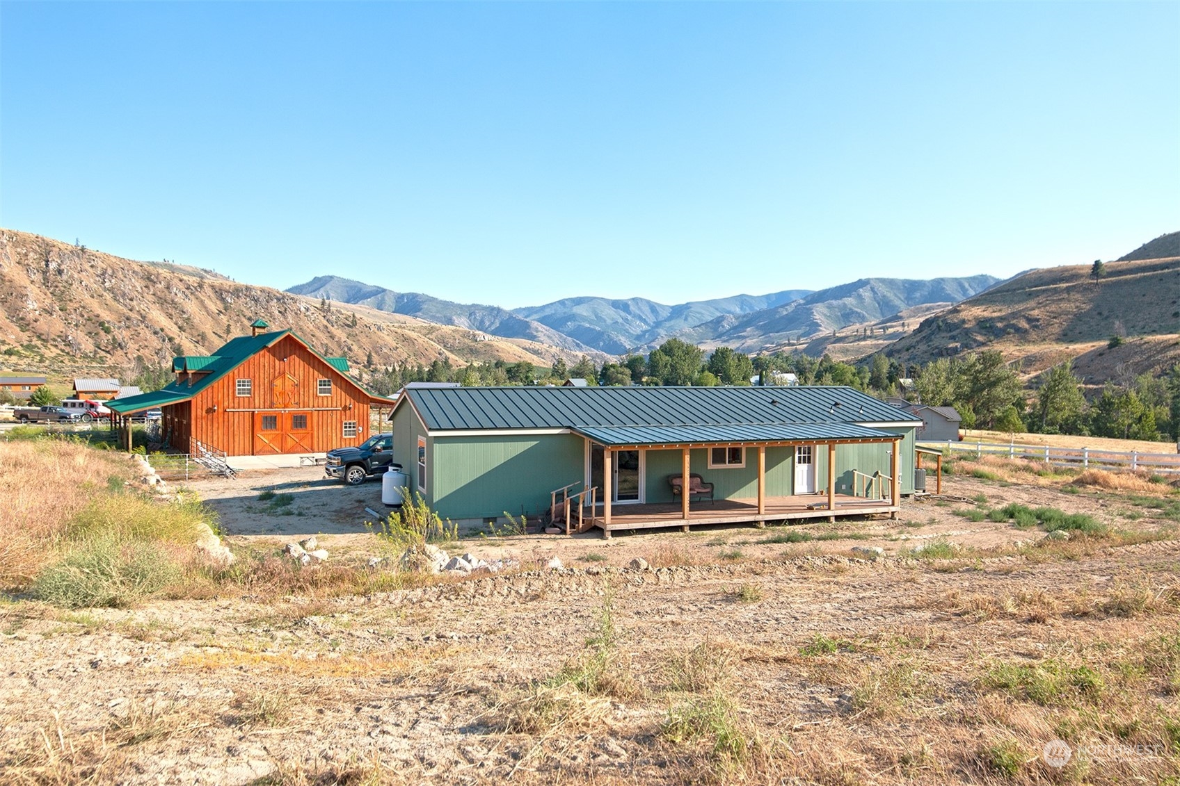 10 Lightning Pine Road Methow, WA 98834 - Photo 4 of 39 a front view of a house with a yard and mountain view in back