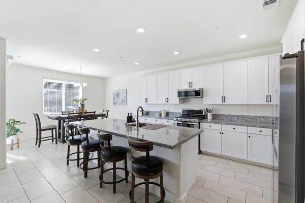 a kitchen with stainless steel appliances granite countertop a sink a stove and a microwave