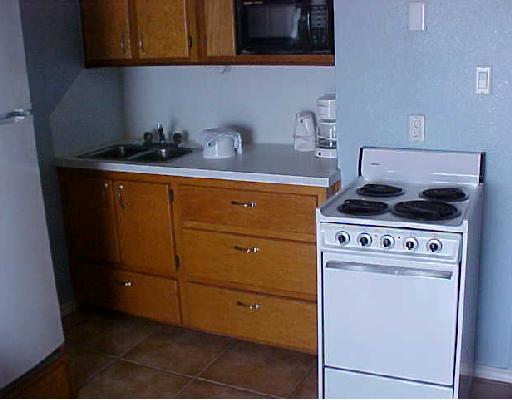 3938 Surfside, Unit 1316 1316 Corpus Christi, TX 78402 - Photo 7 of 7 a kitchen with granite countertop cabinets and a stove